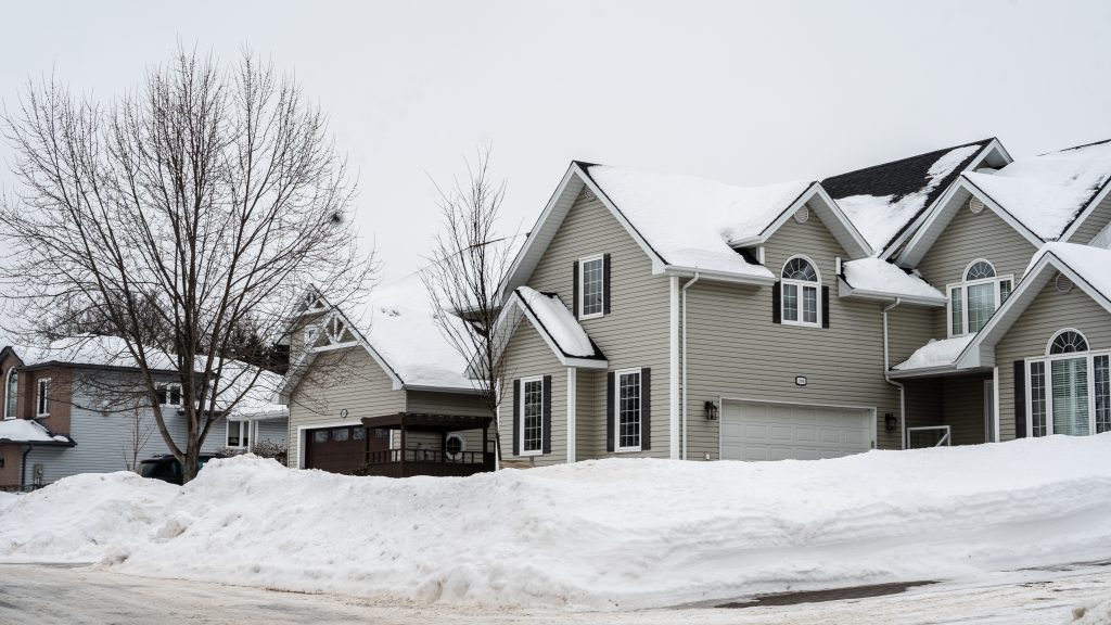 Snow-covered suburban homes on a Canadian residential street in winter